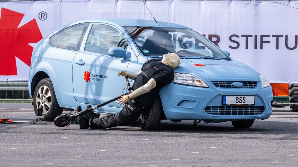 Crashtest mit einem E-Scooter: Ein abbiegendes Auto erfasst den Dummy - der prallt hart auf den Wagen.