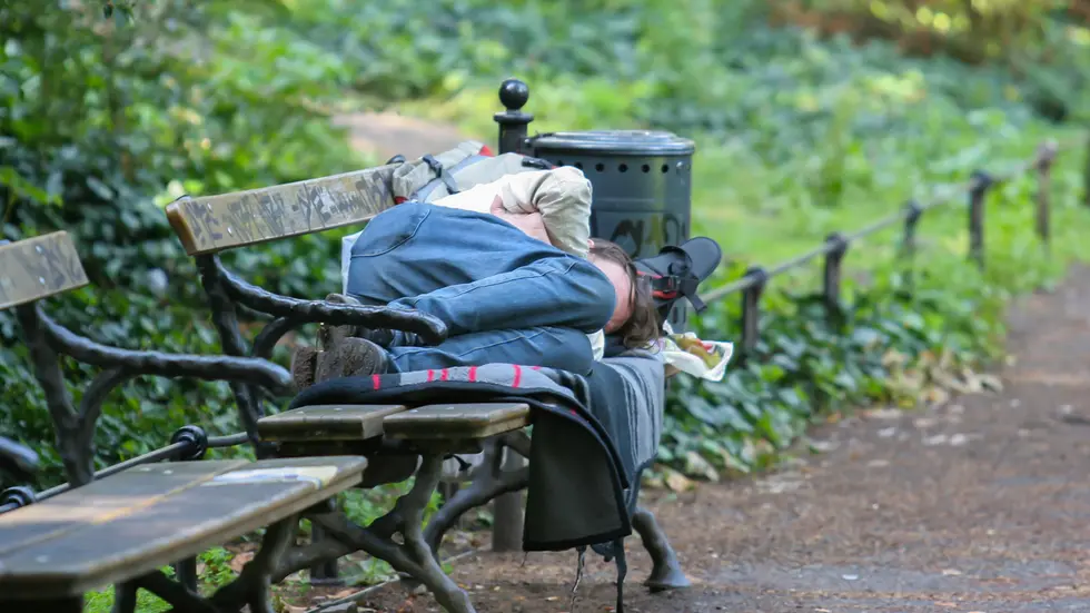 Obdachloser schläft auf einer Parkbank