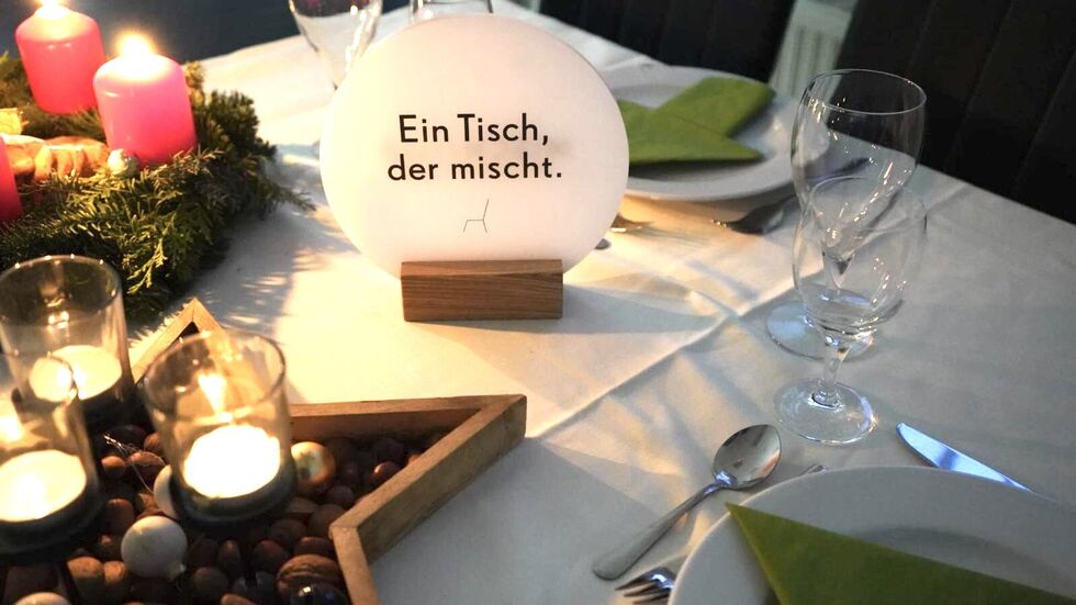 Ein Schild kennzeichnet den Tisch, an dem sich Fremde begegnen können Ein Schild kennzeichnet den Tisch, an dem sich Fremde begegnen können