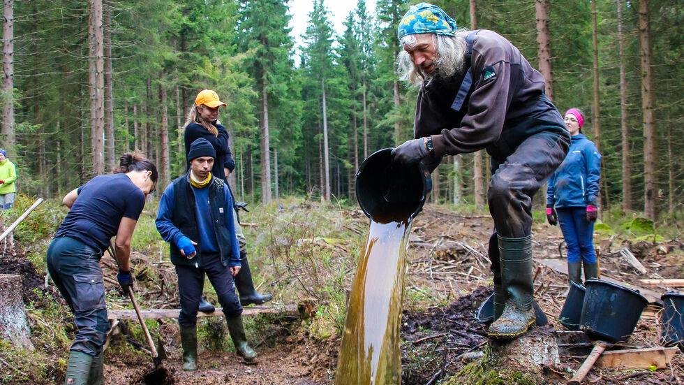 Das Gemisch aus Torf, Fichtensägespänen und Hackschnitzeln wird von Martin Niedermeier mit Moor-Wasser versetzt, bevor es im nächsten Schritt verdichtet wird. Das Gemisch aus Torf, Fichtensägespänen und Hackschnitzeln wird von Martin Niedermeier mit Moor-Wasser versetzt, bevor es im nächsten Schritt verdichtet wird.