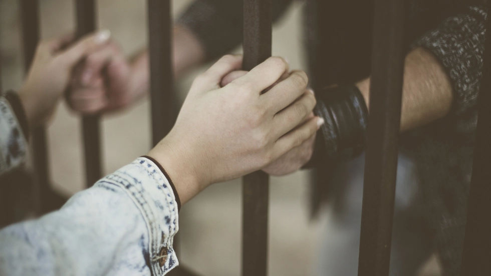 Hände und Gitterstäbe