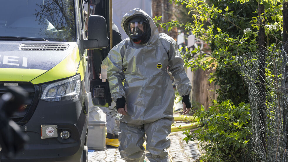 Ein Feuerwehrmann im Schutzanzug bei der Durchsuchung im April in Zeithain. Archivbild