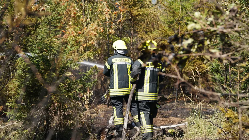 Zwei von etwa 50 Kameraden kämpfen am Boden gegen die Flammen.