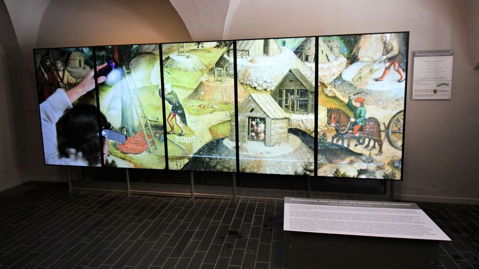 Auf fünf großen Monitoren wird Bergbau und der Bergaltar aus verschiedenen Blickwinkeln gezeigt. 