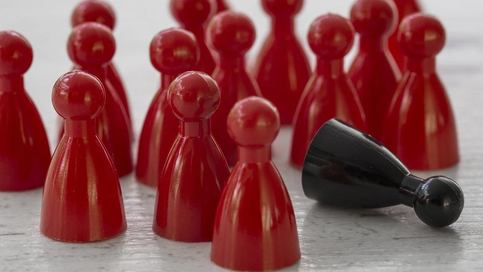 Spielfiguren, alle rot, eine schwarz