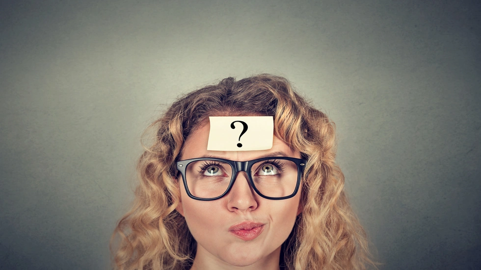 Frau mit Fragezeichen auf der Stirn